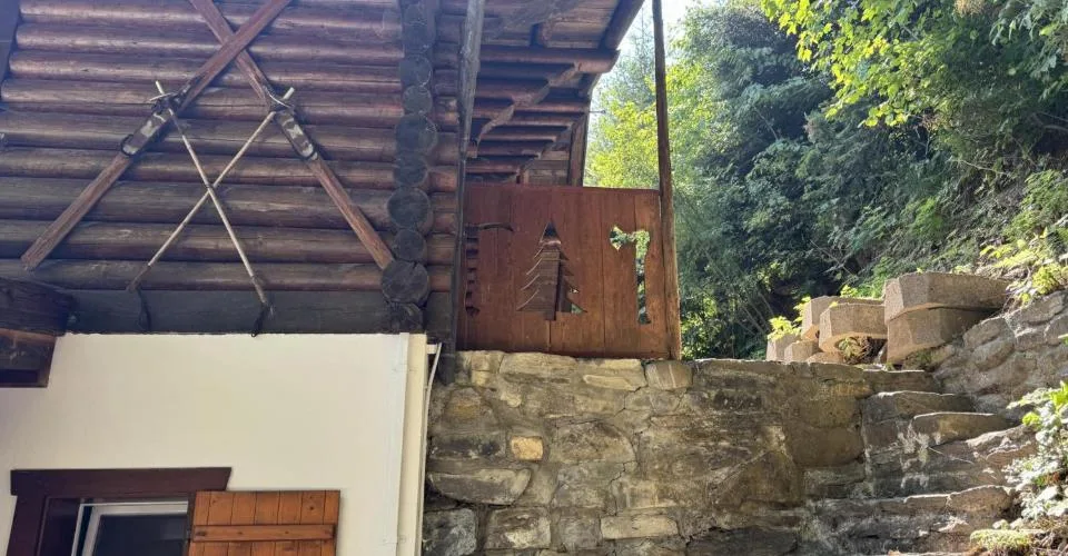 Chalet en rondins d'épicéa dans un écrin de verdure, avec vue sur la plaine du Rhône