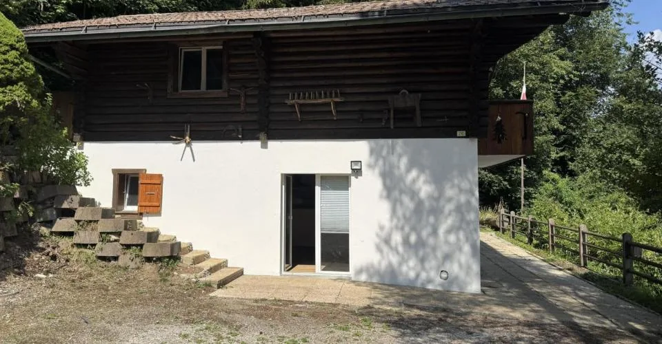 Chalet en rondins d'épicéa dans un écrin de verdure, avec vue sur la plaine du Rhône