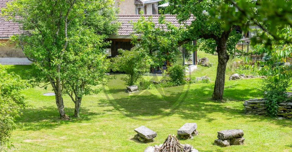 Ferme mitoyenne rénovée avec logements, grange et terrain à bâtir