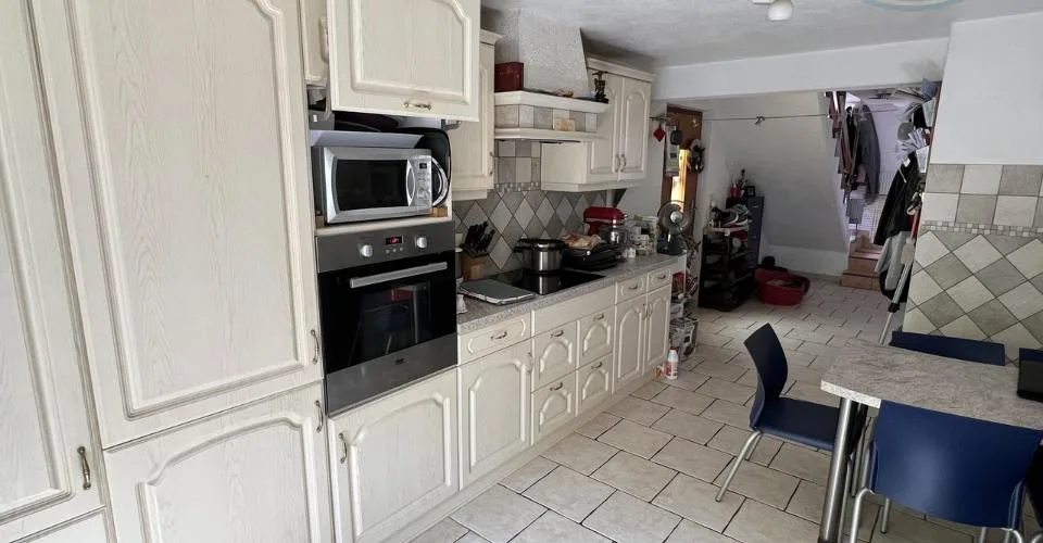 Maison villageoise avec une grande grange et un grand jardin.