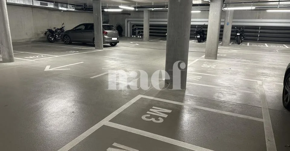 Places de parc intérieures avec borne électrique.