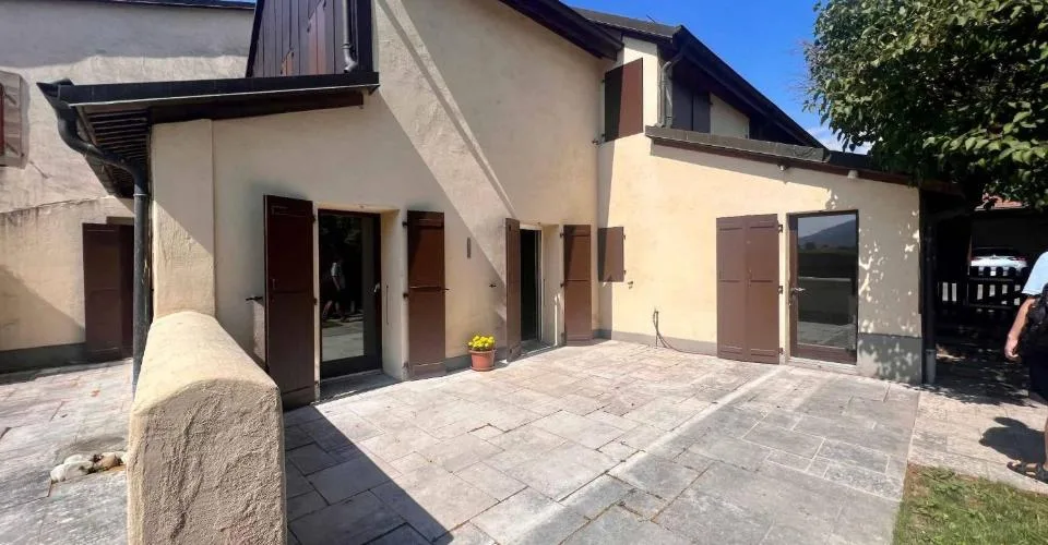 Maison de village avec terrasse et grand jardin arboré.