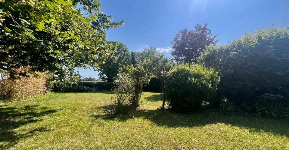 Maison de village avec terrasse et grand jardin arboré.