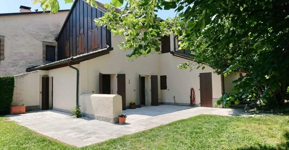 Maison de village avec terrasse et grand jardin arboré.
