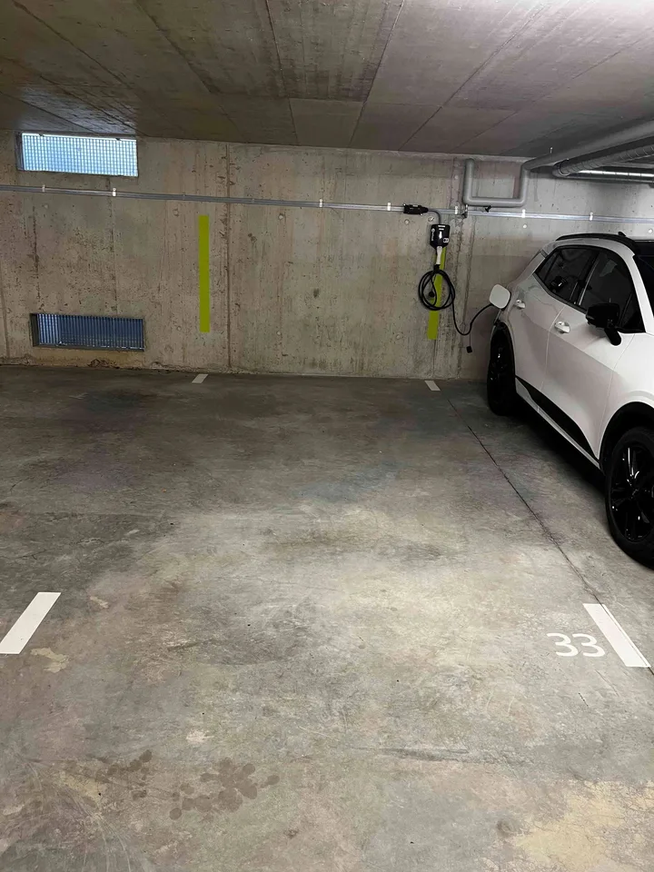 Place de parc avec borne de recharge / Parkplatz mit Ladestation