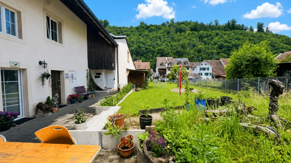 Appartement rénové de 5,5 pièces au 1er étage d'une maison de 2 familles bien entretenue avec balcon, parking et usage de jardin