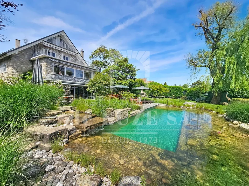 Exclusivité ? Villa individuelle de caractère avec vue lac, piscine naturelle et magnifique jardin paysager.