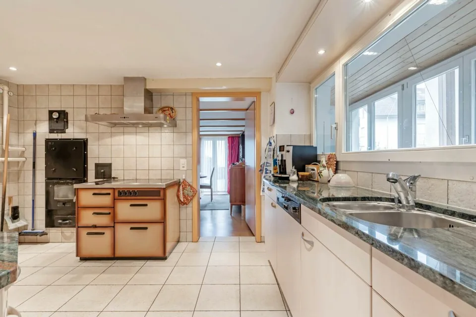 Terrain à bâtir de plus de 1'758 m² avec une maison à deux familles et un grand potentiel de développement dans le centre villageois calme de Remigen