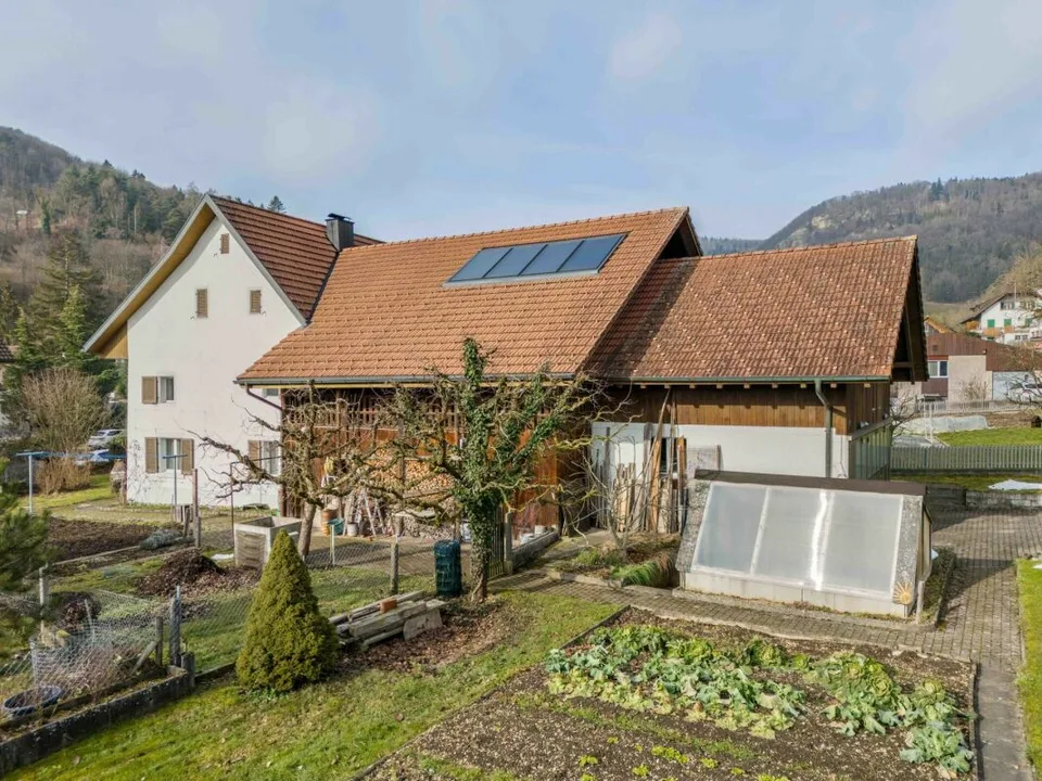 Terrain à bâtir de plus de 1'758 m² avec une maison à deux familles et un grand potentiel de développement dans le centre villageois calme de Remigen