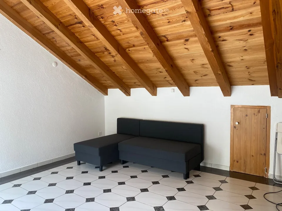 Appartamento mansardato arredato con balcone soleggiato e travi a vista