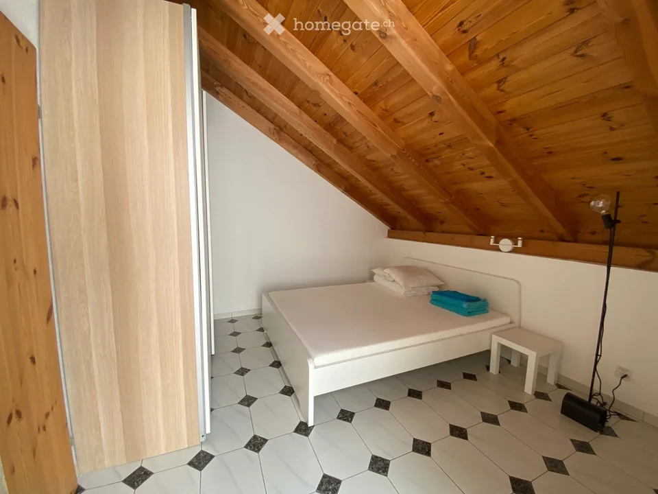 Appartamento mansardato arredato con balcone soleggiato e travi a vista