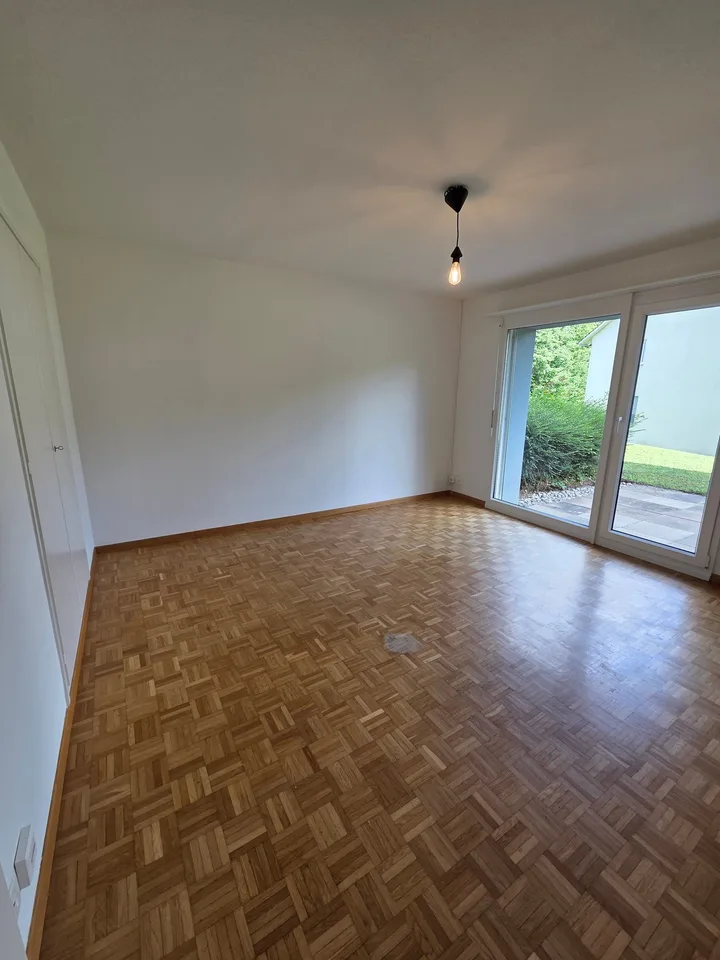 Appartement jardin 2 pièces avec espace de sièges ensoleillé dans un environnement vert