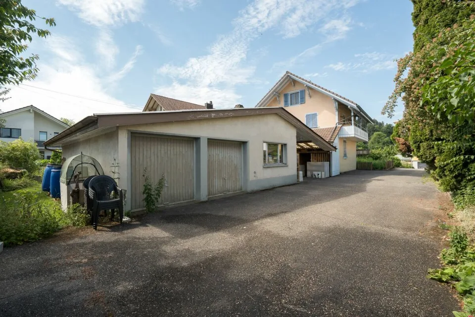 Two-family house with garages, workshop, and storage rooms for sale