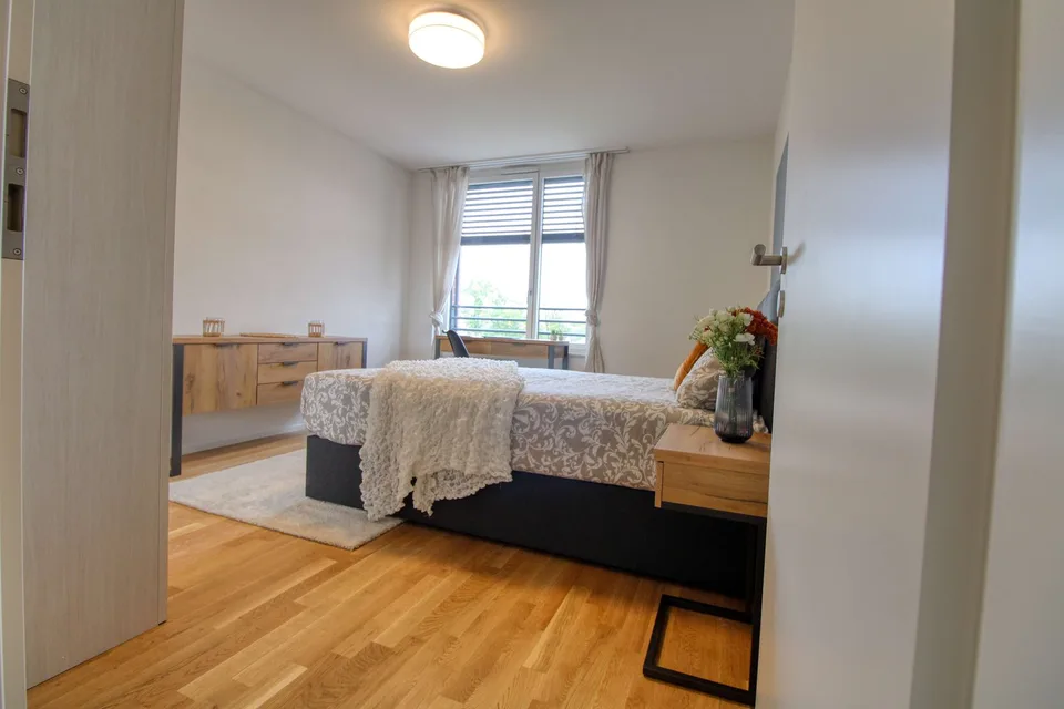 Appartement vivant spacieux à Crissier avec salle de bain privée en suite.