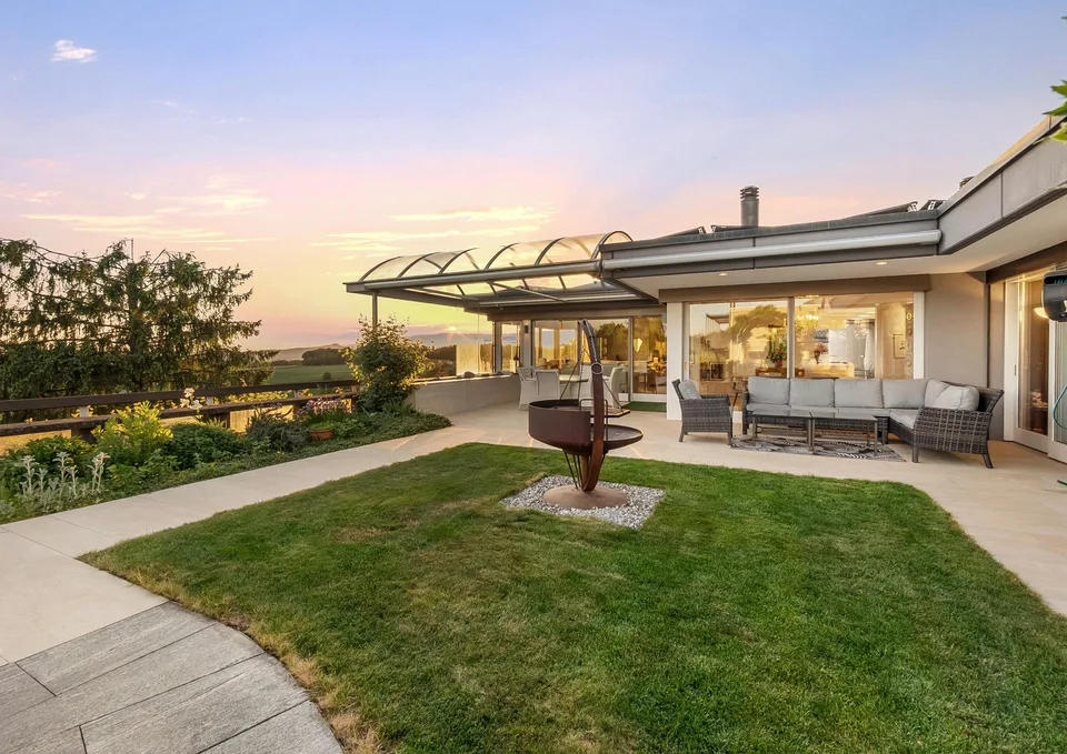 Villa di design senza tempo su una pendice soleggiata con un rifugio di giardino da sogno