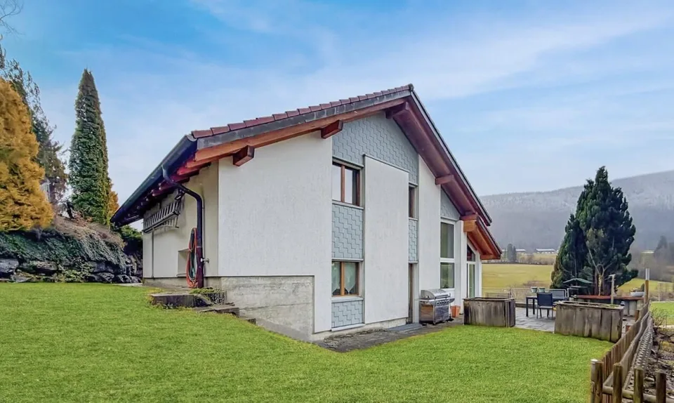 Eine von Licht durchflutete Villa, zwischen Himmel und Bergen schwebend