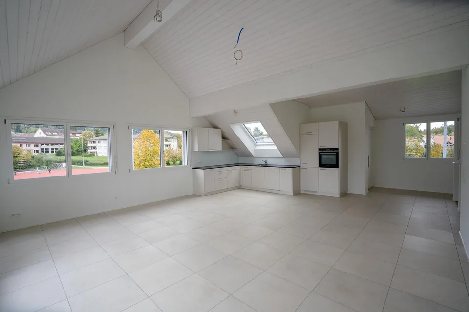 Grand appartement neuf au dernier étage dans un emplacement central avec vue sur les montagnes, garage inclus