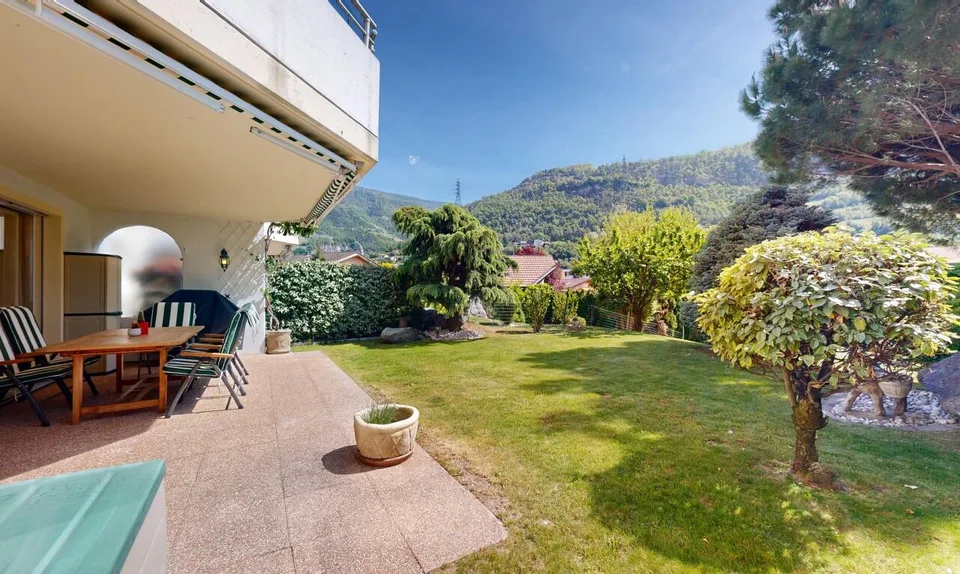 Baumgesäumter Garten und sonnige Terrasse in Bramois
