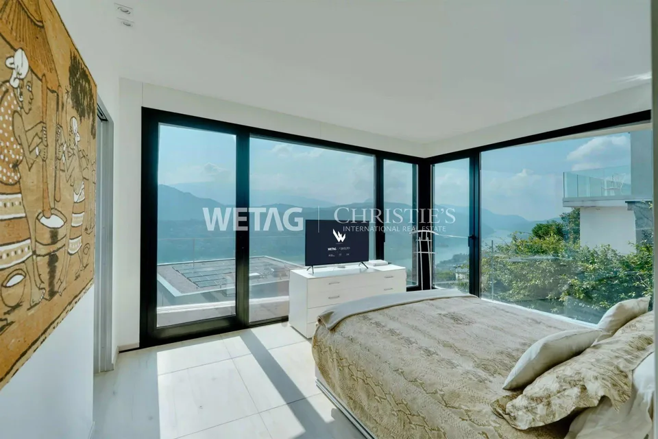 Zum Verkauf in Lugano-Vernate: Moderne Attikawohnung mit spektakulärer Aussicht auf den Luganersee & privatem Garten