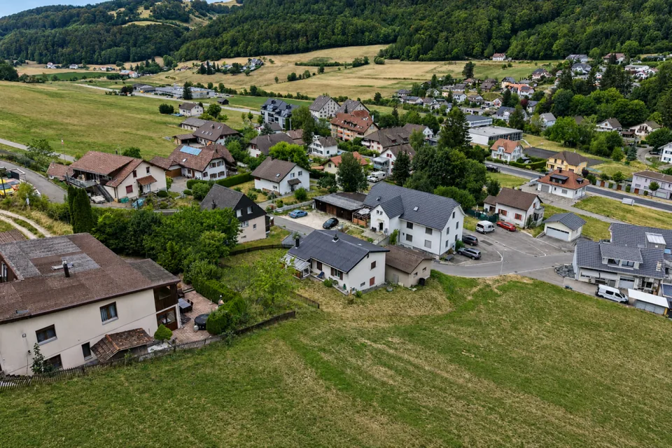Terreno edificabile con progetto di costruzione nuova per quattro piccole case in una posizione soleggiata ai margini del bosco