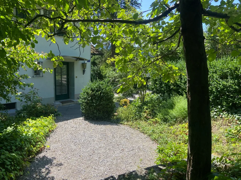 Maison unifamiliale mitoyenne d'un seul côté avec bâtiment de garage séparé et jardin paysager