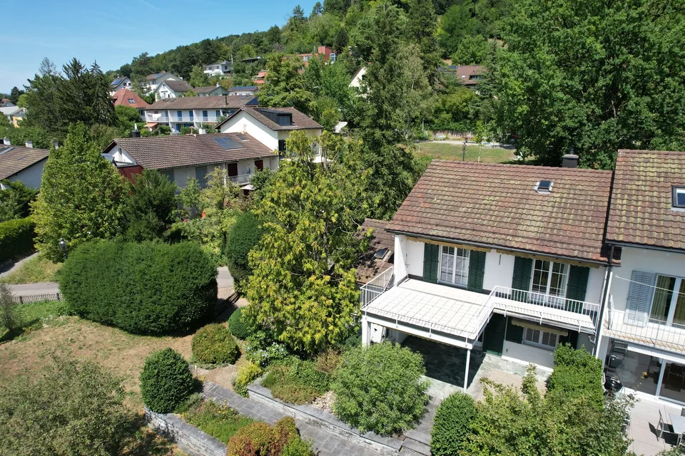 Maison unifamiliale mitoyenne d'un seul côté avec bâtiment de garage séparé et jardin paysager