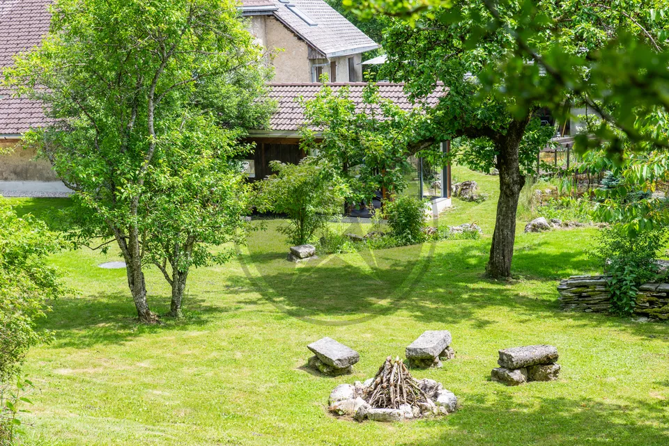 Ferme mitoyenne rénovée avec logements, grange et terrain à bâtir