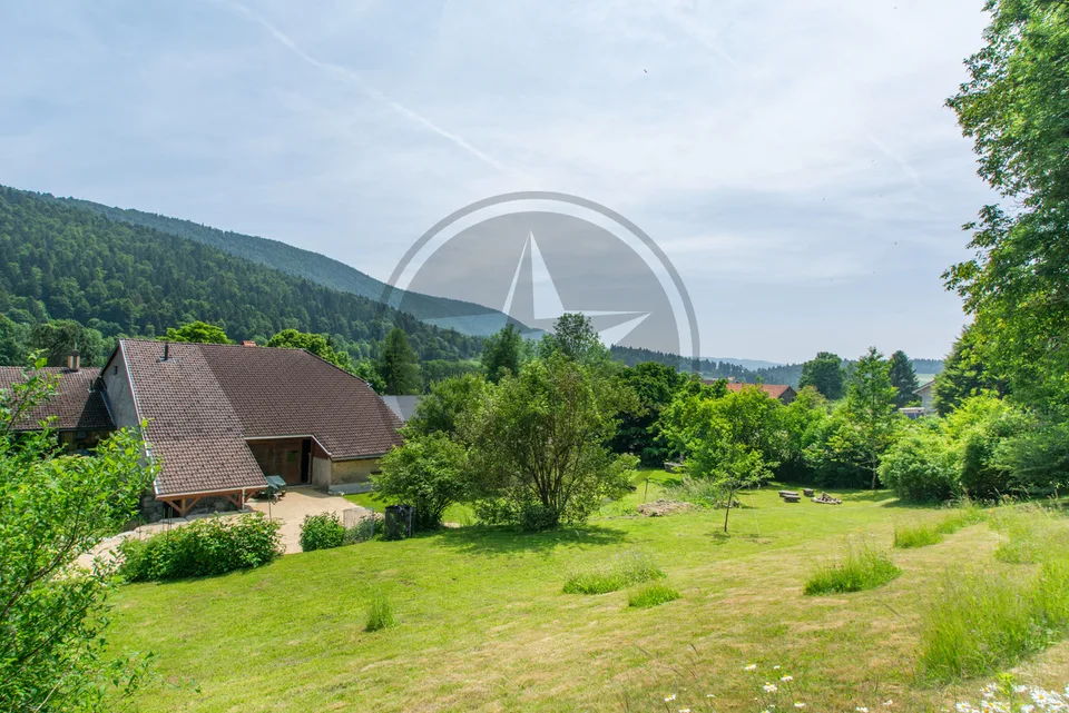 Ferme mitoyenne rénovée avec logements, grange et terrain à bâtir