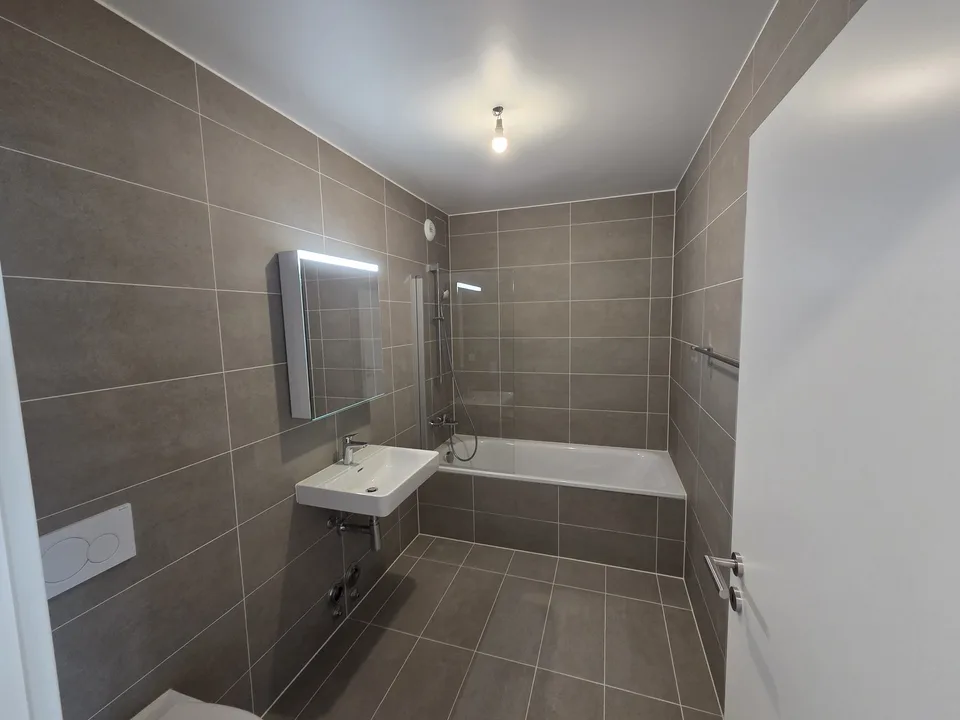 Appartement neuf 4,5 pièces au 6ème étage, traversant et lumineux, 2 balcons vue dégagée. Place de parc en option (parking souterrain, borne EV). À 6 min à pied du M1, 10 min de l'EPFL/UNIL.